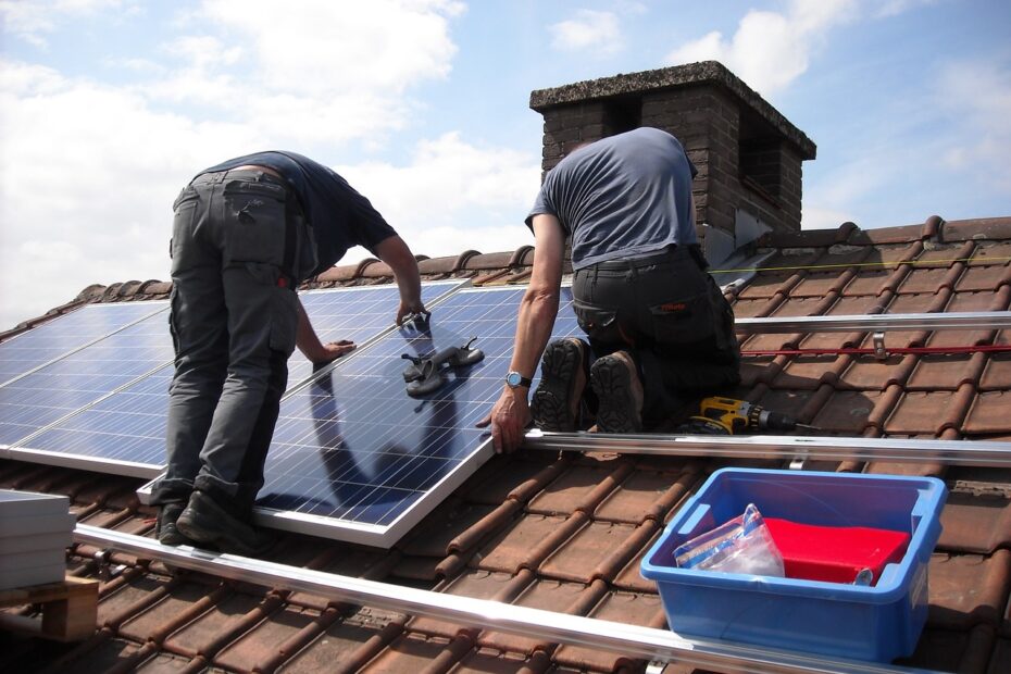 solar installers on a roof with panels