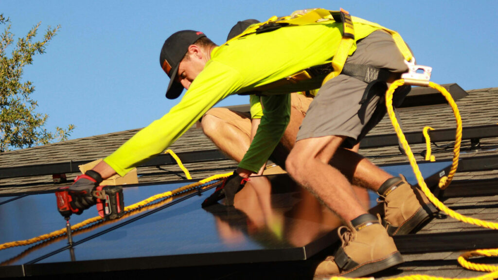 close-up of solar roof worker installing panel